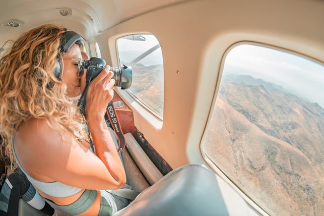 A photographer riding in a general aviation airplane snaps a photo of the Arizona landscape below